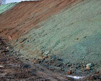 A dirt hill partially covered with stabilization spray